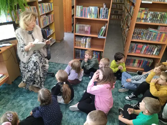 Pani bibliotekarka czyta uczniom z kl. IIb wiersze J. Brzechwy.