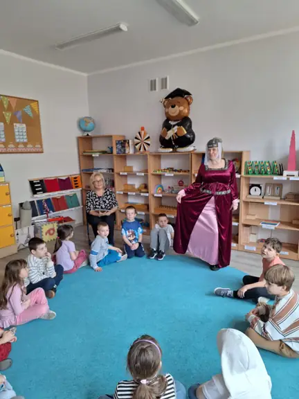 Uczniowie kl. Ia słuchają czytanej im legendy oraz podziwiają strój mieszczki.