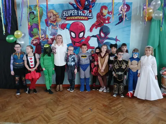 Uczniowie klasy 1c w wychowawczynią pozuja do zdjęcia w przebraniach