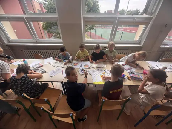 Grupa uczniów przygotowuje swoje koszulki- malując na nich.