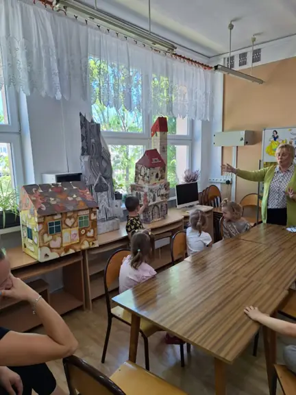 Chłopiec wskazuje wybrany bajkowy domek i podaje, kto w nim mieszkał.