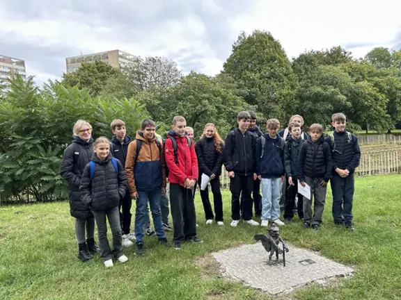 uczniowie z Eberswalde stoją przy gryfiku o nazwie dom kata