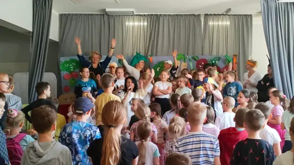 Dzieci na scenie bawią się i śpiewają