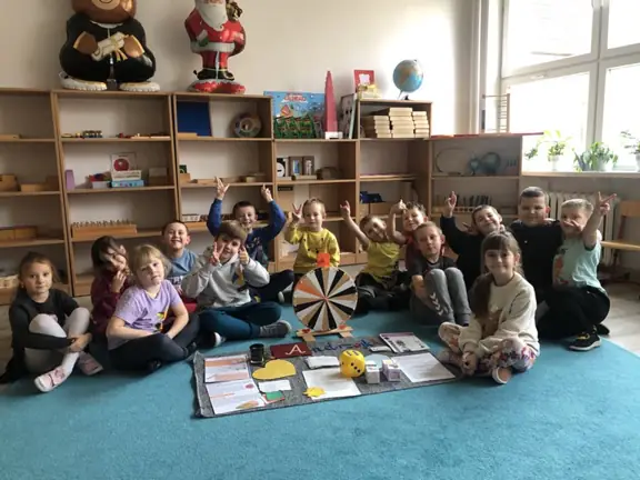 Uczniowie klasy pierwszej a pozują do zdjęcia podczas wróżb andrzejkowych.