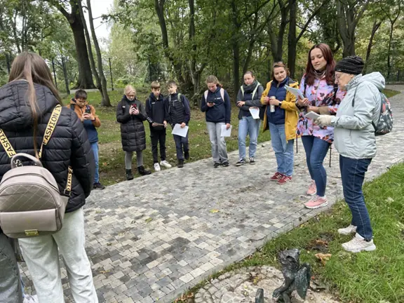 Uczniowie stoją przy gryfiku o nazwie Kirkut.