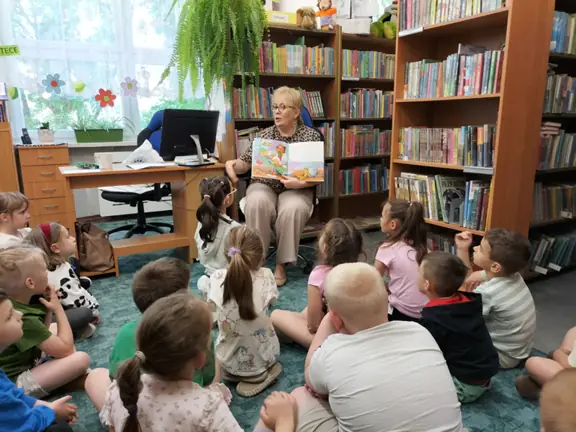 pani-bibliotekarka-rozmawia-z-dziecmi-i-demonstruje-im-ilustacje-z-czytanej-ksiazeczki--jpg