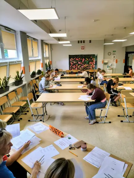 Uczestnicy konkursu wykonują ćwiczenia frazeologiczne, a komisja ocenia ich zadania.