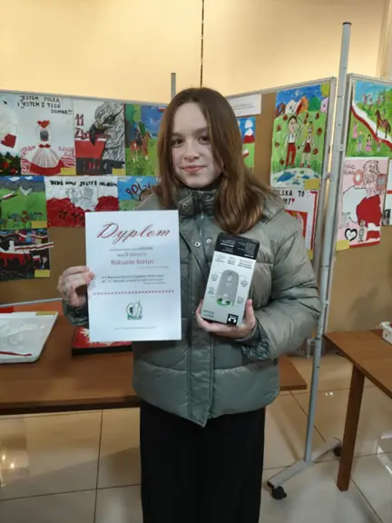 Roksana pozuje z dyplomem i nagrodą.