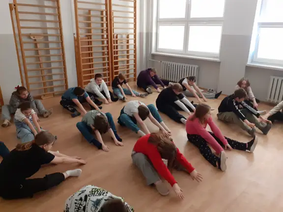 Uczniowie ćwiczą jogę.