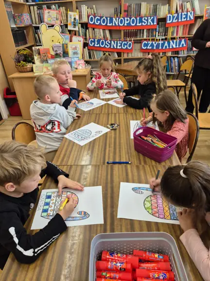 Dzieci z grupy 01 kolorują geometryczne wzory na tułowiu kota.