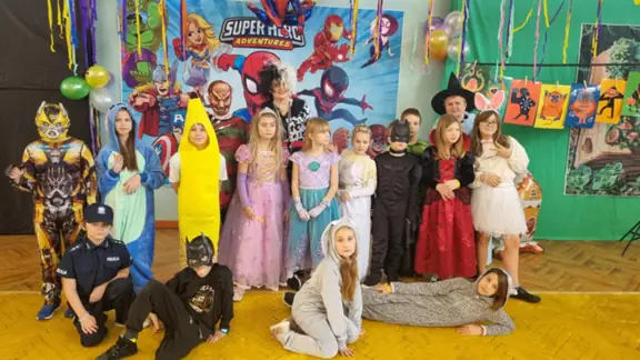 Uczniowie klasy 3a z wychowawcami pozują w strojach karnawałowych na balu.