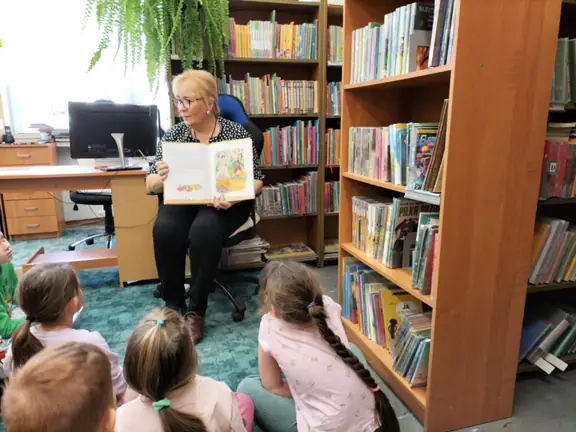 bibliotekarka-demonstruje-przedszkolakom-ilustracje-do-bajki-swiniopas--jpg