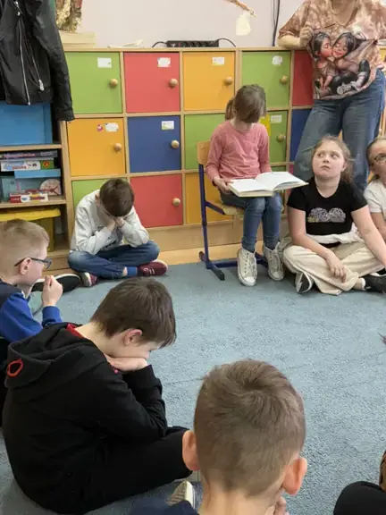 Uczennica kl. IIb czyta dzieciom książkę.