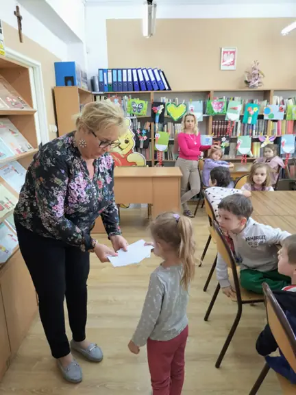 Dziewczynka losuje kopertę z bajkową zagadką.