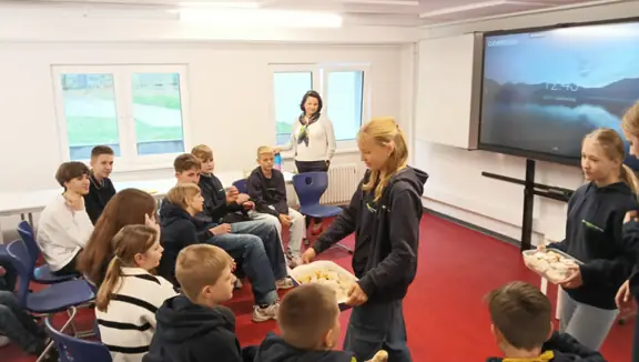 Uczennice częstują grupę upieczonymi rogalikami.