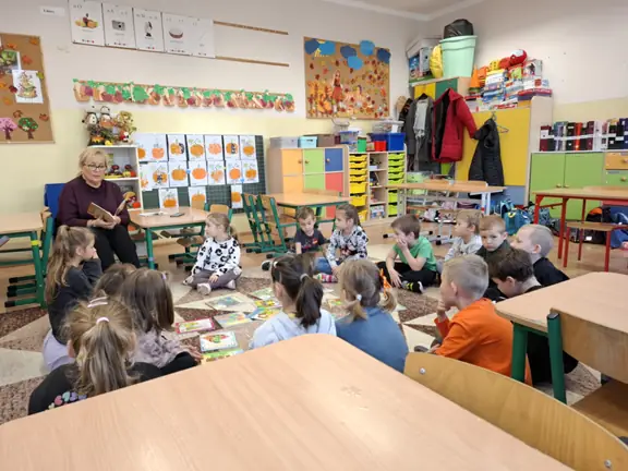 Przedszkolaki z grupy 01 słuchają czytanego przez p. bibliotekarkę opowiadania - Franklin idzie do szkoły.