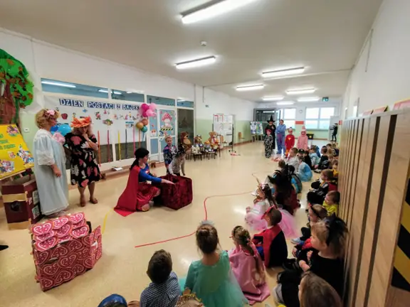 Dziewczynka sięga rączką do tajemniczego pudełka