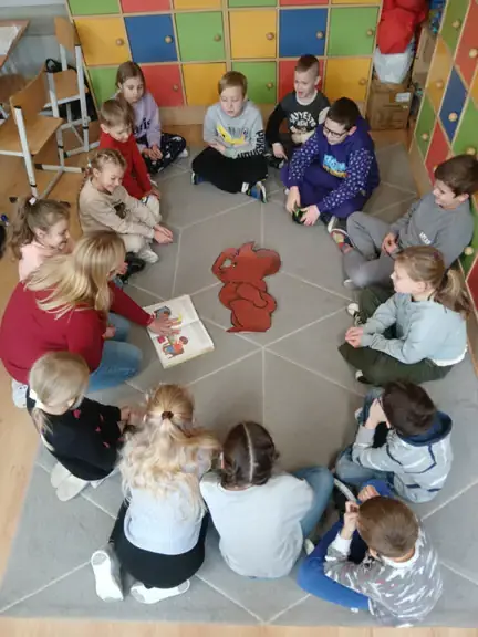 Wychowawczyni kl. IIc czyta dzieciom bajkę o misiu.