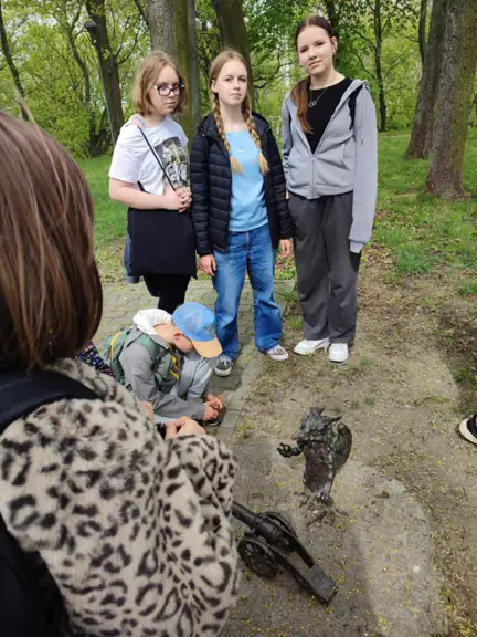 Uczennice pozują w parku obok gryfika