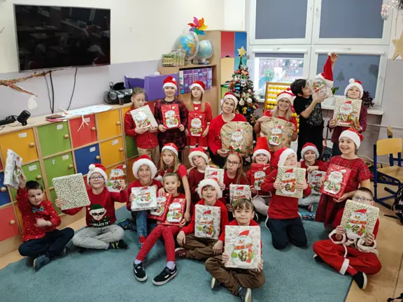 Uczniowie z kl. IIb pozują do zdjęcia z prezentami od Mikołaja.