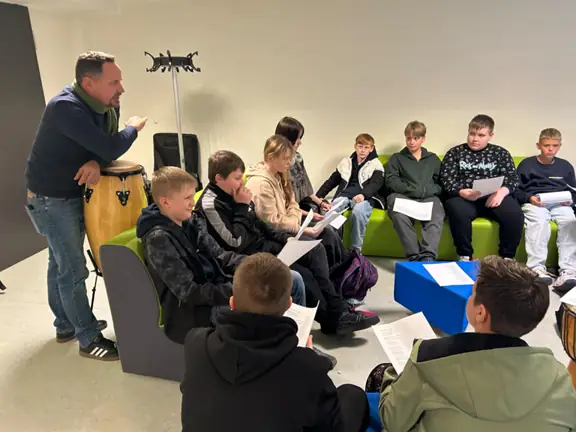 Grupa uczniów ćwiczy tekst piosenki