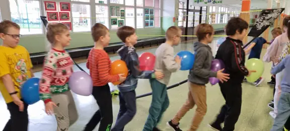 Dzieci tworzą balonowego węża 