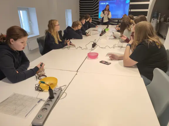 Uczniowie pracują z długopisami 3D