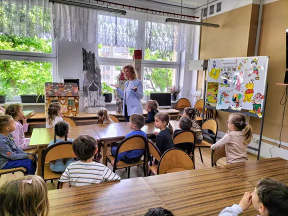 Pani bibliotekarka rozmawia z przedszkolakami o ulubionych bohaterach bajek.