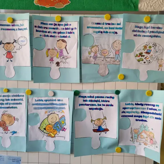 Obrazki pokolorowane przez uczniów klasy trzeciej a, dotyczące autyzmu, w kształcie puzzli.