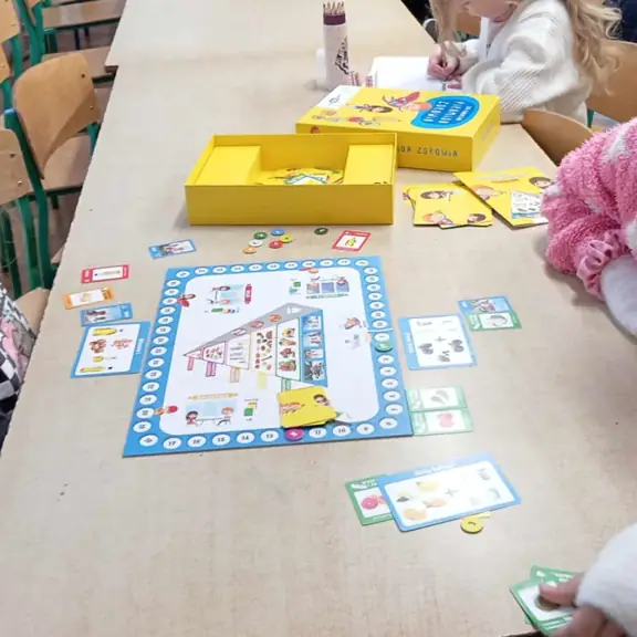 Uczennice grające w grę planszową dot. zdrowego odżywiania