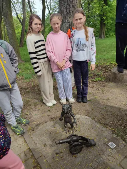Uczennice pozują w parku obok gryfika