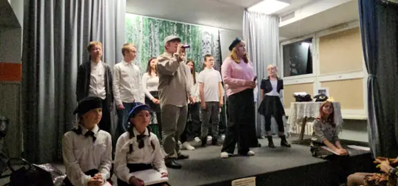 Uczniowie śpiewają na scenie piosenki patriotyczne