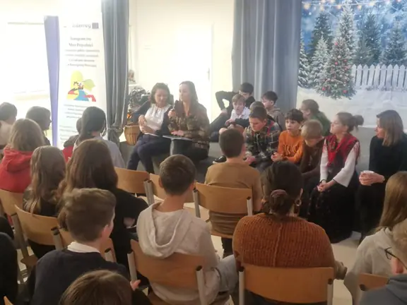 Grupa uczniów wraz z opiekunami dyskutuje na temat teatru