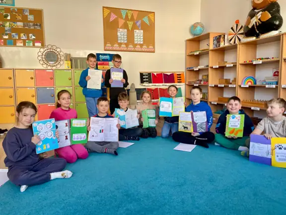 Uczniowie z kl. IIIc prezentują ilustracje do przeczytanej książki O psie, który jeździł koleją.