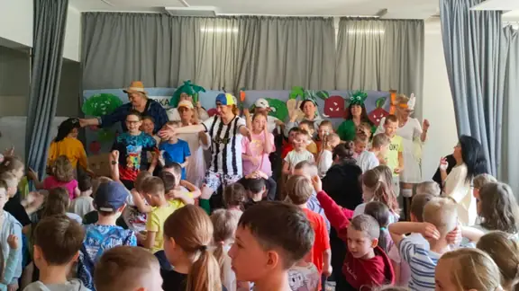 Dzieci na scenie bawią się i śpiewają