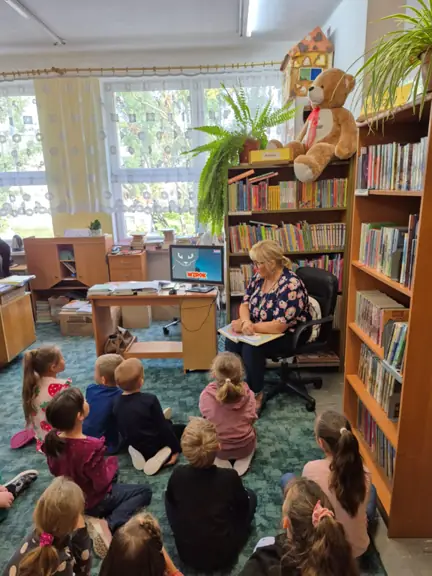 Dzieci oglądają film edukacyjny o kotach.