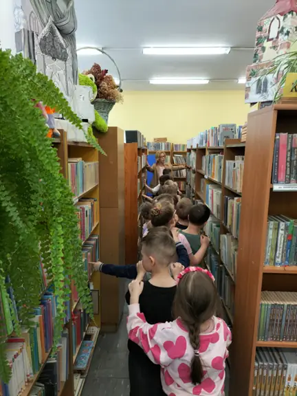przedszkolaki-spaceruja-pomiedzy-bibliotecznymi-regalami-i-ogladaja-ksiazki--jpg