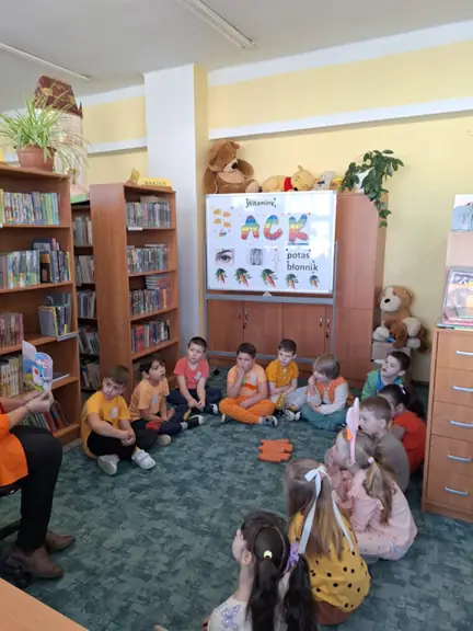 Dzieci z grupy 01 słuchają czytanej im książeczki pt. Przyjęcie u Karoliny z serii Marchewkowy ogród.