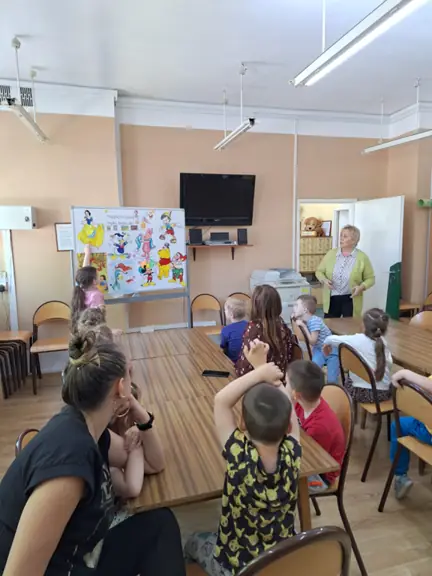 Dziewczynka wskazuje na tablicy ulubionego bohatera bajki i podaje jego imię.