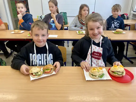 Chopiec i dziewczynka z klasy trzeciej c prezentują zrobione przez siebie zdrowe kanapki