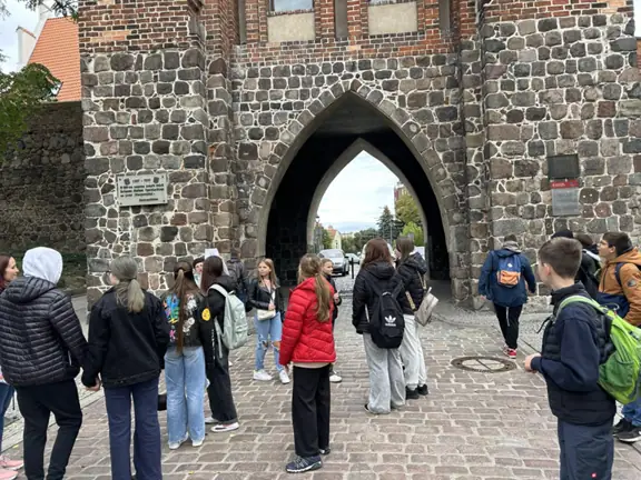 Grupa uczniów stoi przy Bramie Pyrzyckiej.