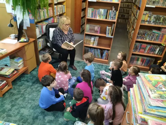 Bibliotekarka szkolna czyta dzieciom z gr. 01 bajkę Księżniczka na ziarnku grochu.