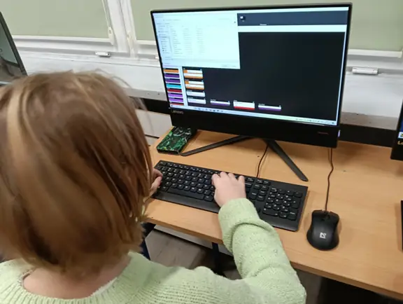 uczennica tworzy program dla robota JD Humanoid w środowisku RoboScratch