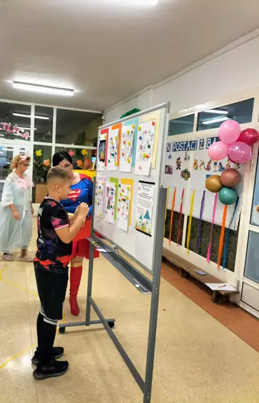 Chłopiec odsłania puzzla z układanki i odgaduje tytuł bajki