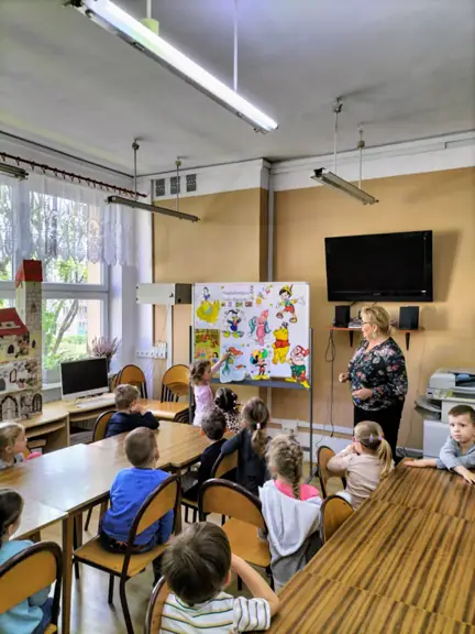 Dziewczynka rozpoznała bohatera bajki i wskazuje go wśród innych postaci.