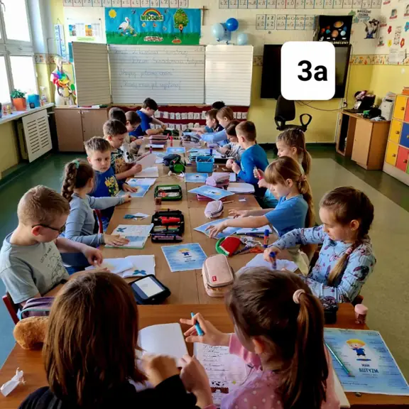 Uczniowie klasy trzeciej a sporządzają notatkę na temat autyzmu.