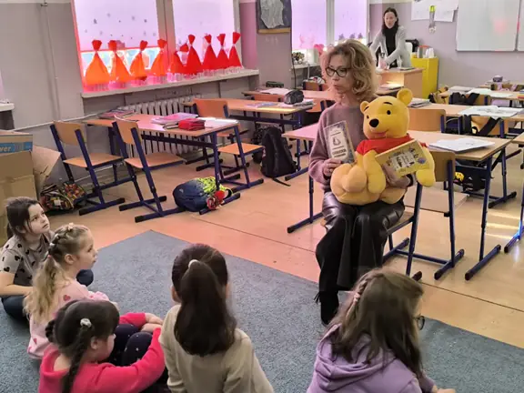 bibliotekarka-prezentuje-ksiazki-a-a--milnea-uczniom-z-kl--1b--jpg