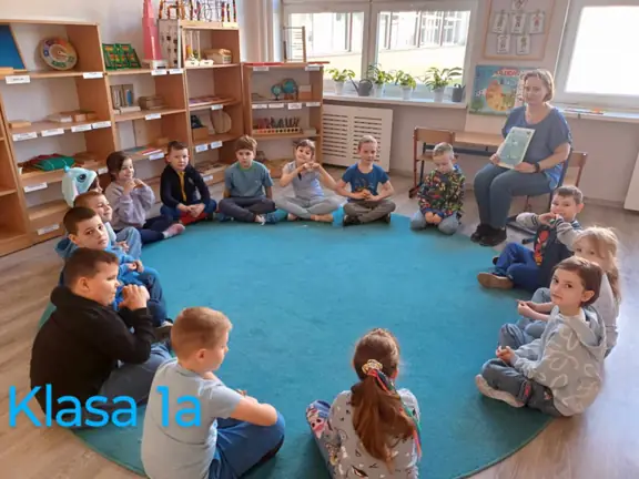 Klasa pierwsza a siedzi w kręgu i słucha informacji przekazywanych przez wychowawcę, dotyczącą autyzmu.