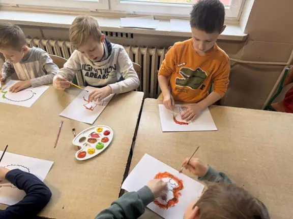 Uczniowie pracujący nad jesiennymi obrazkami