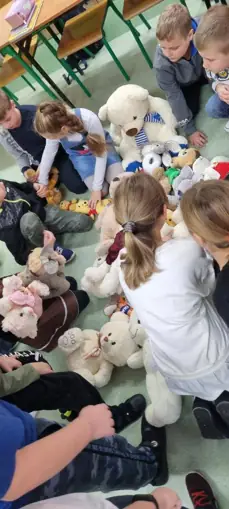 Uczniowie z kl. IIIa układają z misiów wielkiego misia.